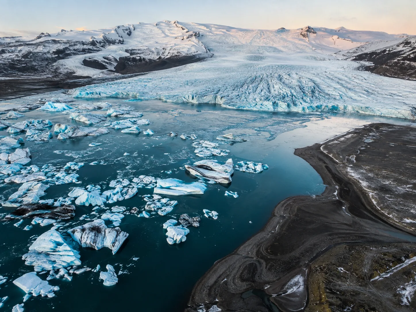 a glacier flowing toward an iceberg lagoon.