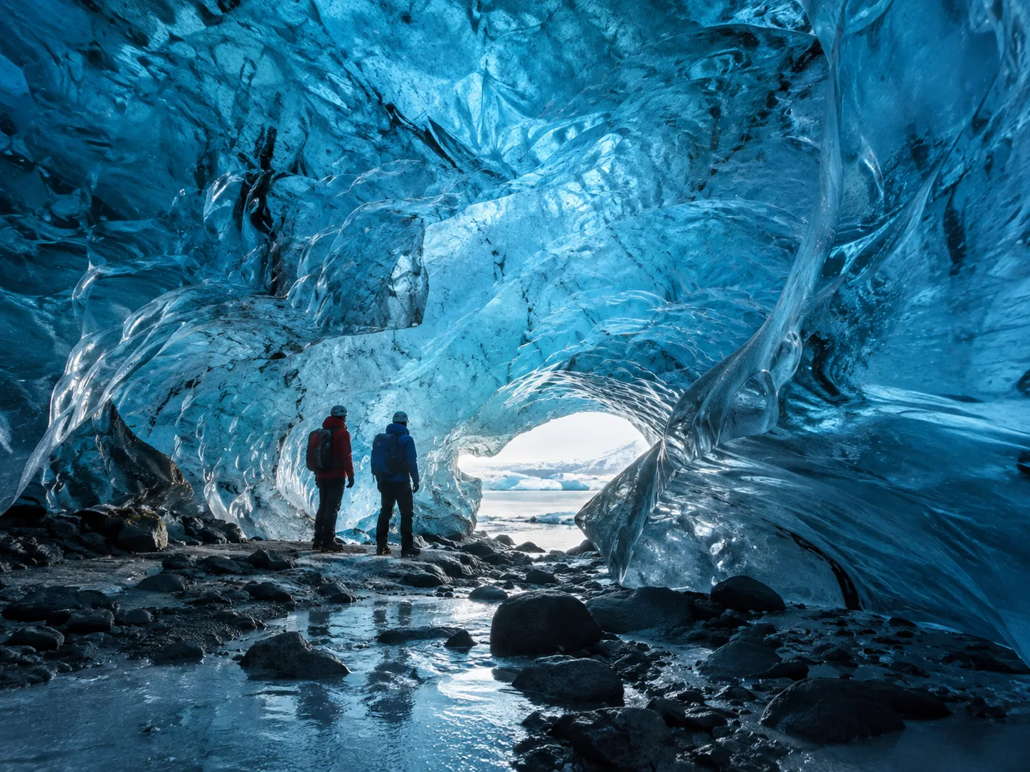 visitors inside a blue glacier cave.